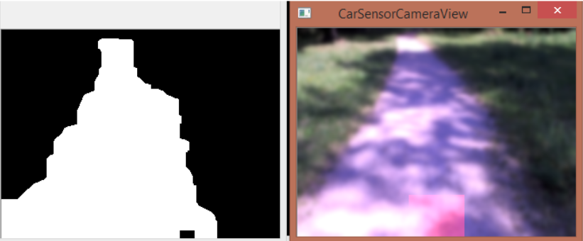 Screenshot von zwei Fenstern mit Kamerabildern. Im rechten Bild ist ein ist ein Weg mit Wiese auf beiden Seiten zu sehen. Das linke Bild zeigt das Ergebnis der Verarbeitung und ist Binär, also Schwarz und Weiß. An der Stelle wo der Weg im rechten Bild war ist es im linken Weiß, sonst Schwarz.