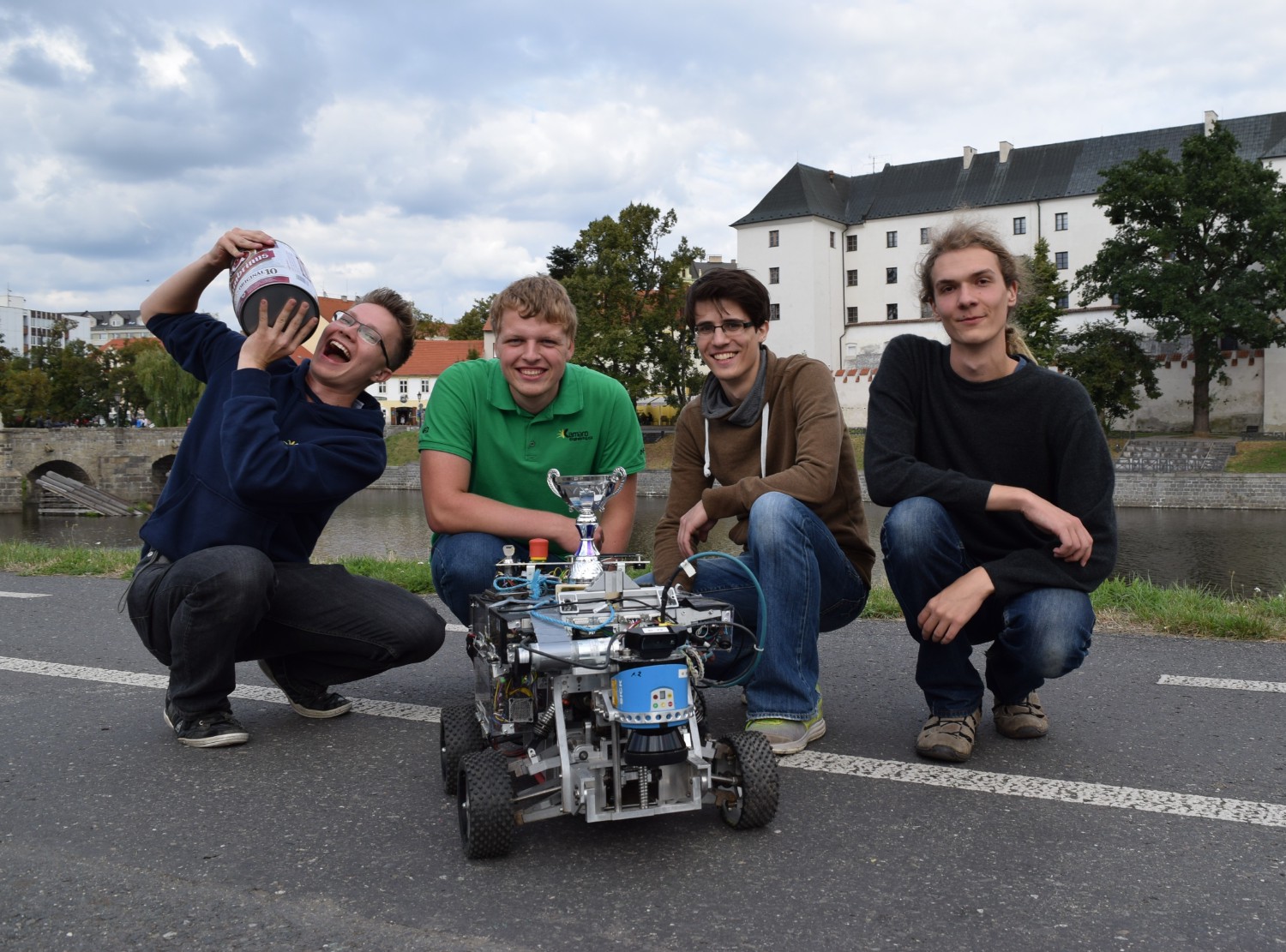 vier Kamaros in der Hocke hinter dem Roboter Beteigeuze. Der linke Kamaro hat ein Fass Bier auf der Schulter